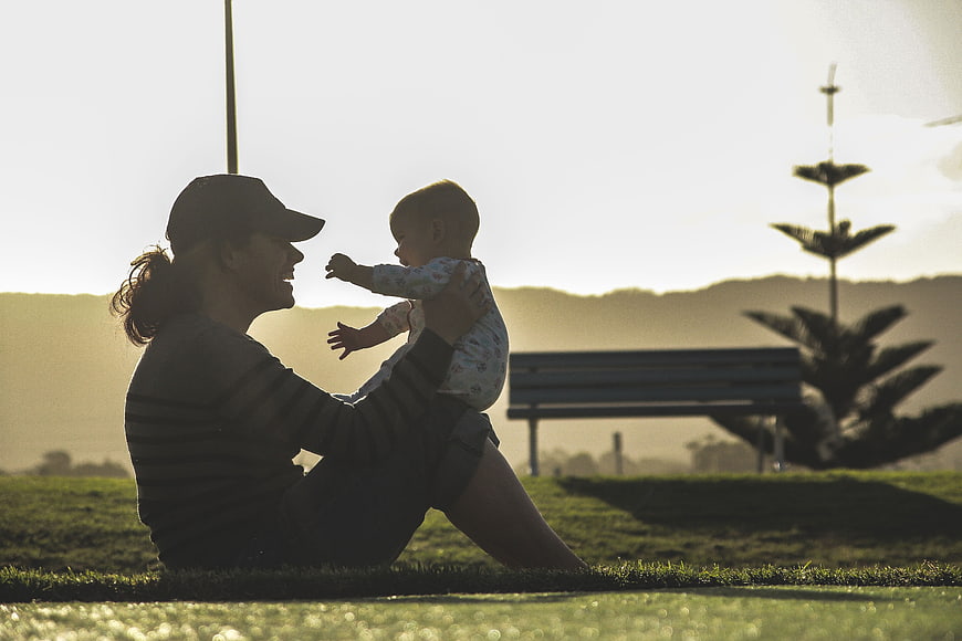 Mother and Baby Playing in Park at Sunset