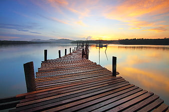 Wooden Pier Extending into Calm Lake at Sunset