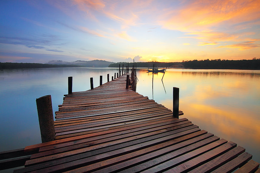 Wooden Pier Extending into Calm Lake at Sunset