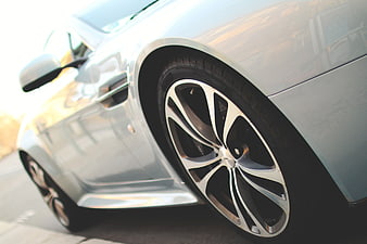 Close-up of silver car wheel and side profile