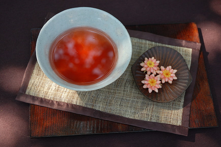 Traditional Korean Omija Tea and Flower Shaped Sweets on Wooden Tray