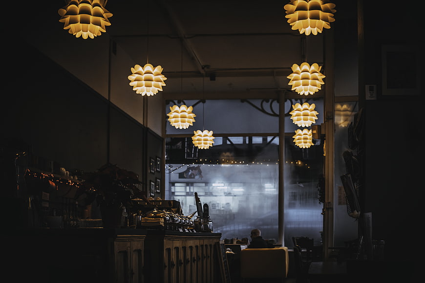 Cozy Cafe Interior with Hanging Pendant Lights and Espresso Machine