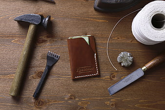 Leather cardholder with tools on wooden table