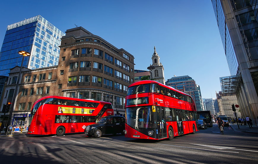 London street scene with red double-decker buses and black taxi