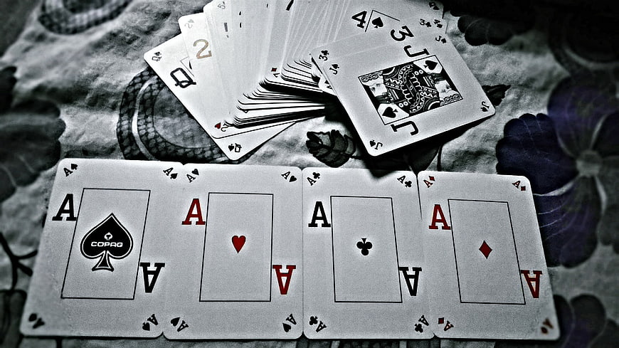 Four Aces Poker Hand on Floral Tablecloth
