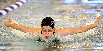 Female Swimmer Performing Butterfly Stroke in Pool