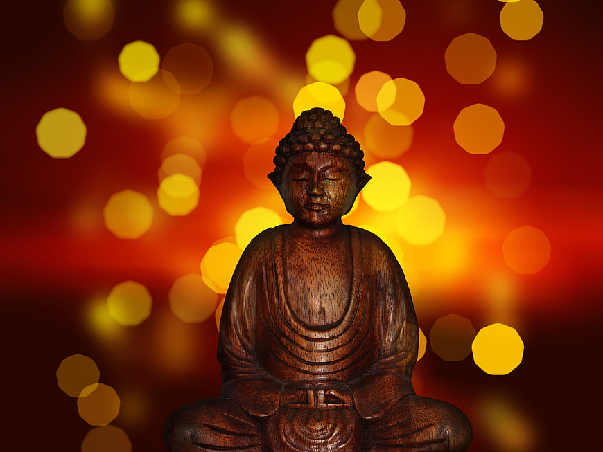 Wooden Buddha Statue with Golden Bokeh Background