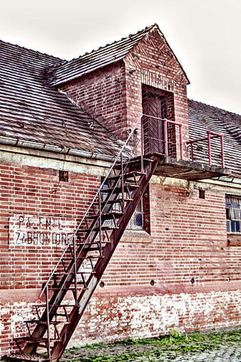 Rusty metal stairs on abandoned red brick industrial building