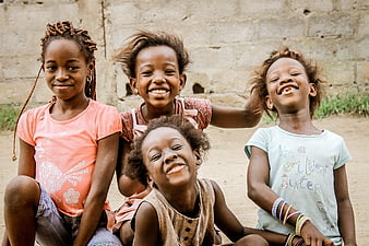 Four smiling African girls sitting together outdoors