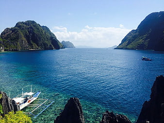 Tropical Lagoon with Traditional Outrigger Boat and Limestone Cliffs