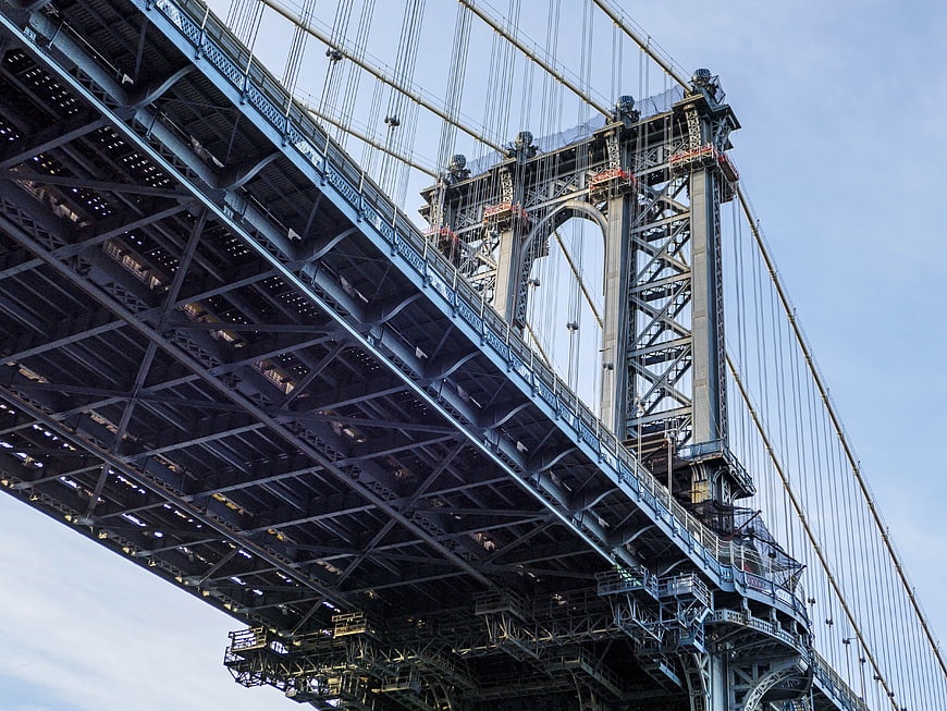 Low angle view of Manhattan Bridge steel structure and suspension cables
