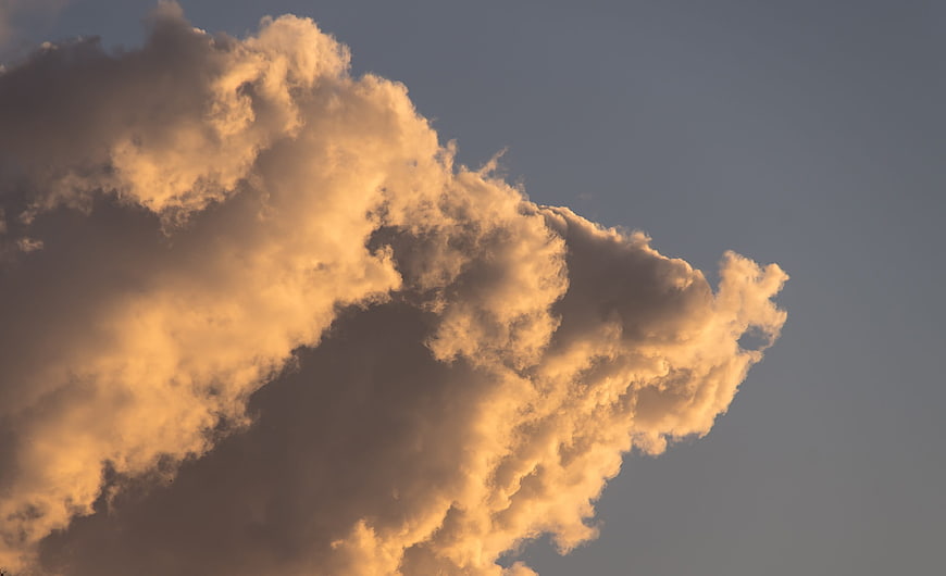 Dramatic golden sunset cloud formation against blue sky