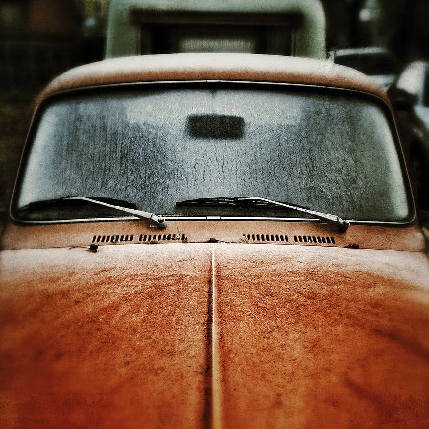 Close-up of rusty vintage car hood and windshield