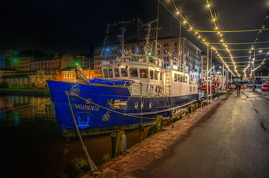 Blue fishing boat Muikku docked at Helsinki harbor at night