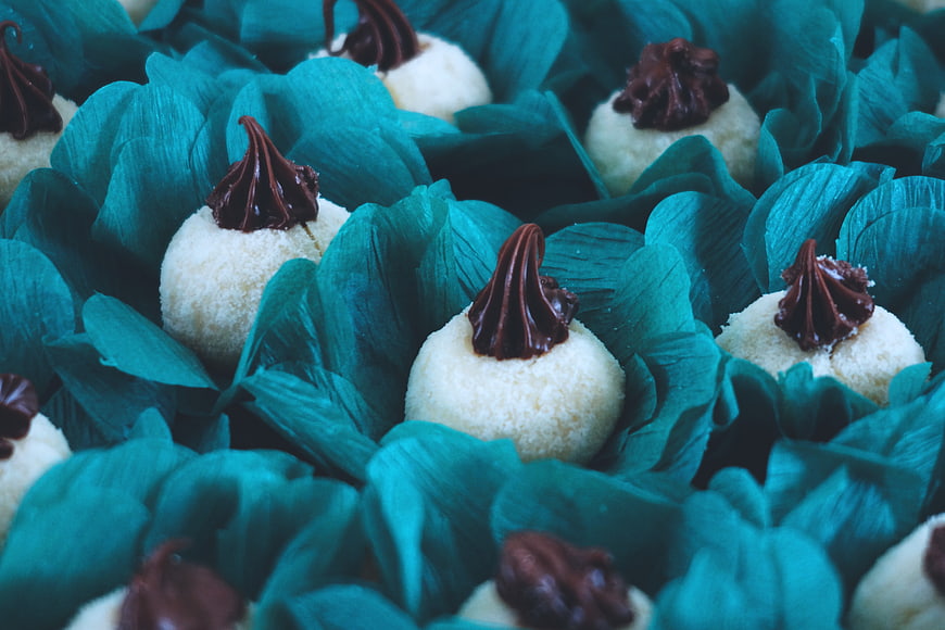 Close-up of white truffles with chocolate in teal wrappers