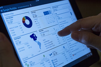 Hand interacting with financial portfolio app on tablet screen