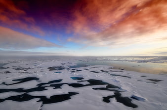 Aerial View of Arctic Ice Floes Under Dramatic Sunset Sky