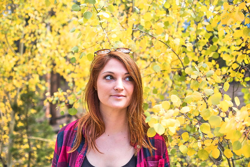 Woman with Red Hair in Plaid Shirt Amidst Yellow Autumn Leaves