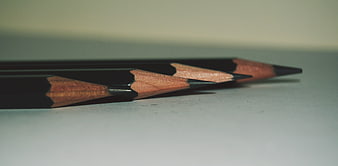 Close-up of black pencils on white paper