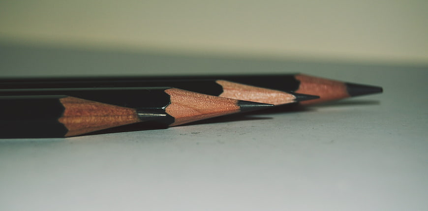 Close-up of black pencils on white paper