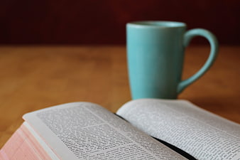 Open Bible and Blue Coffee Mug on Wooden Table