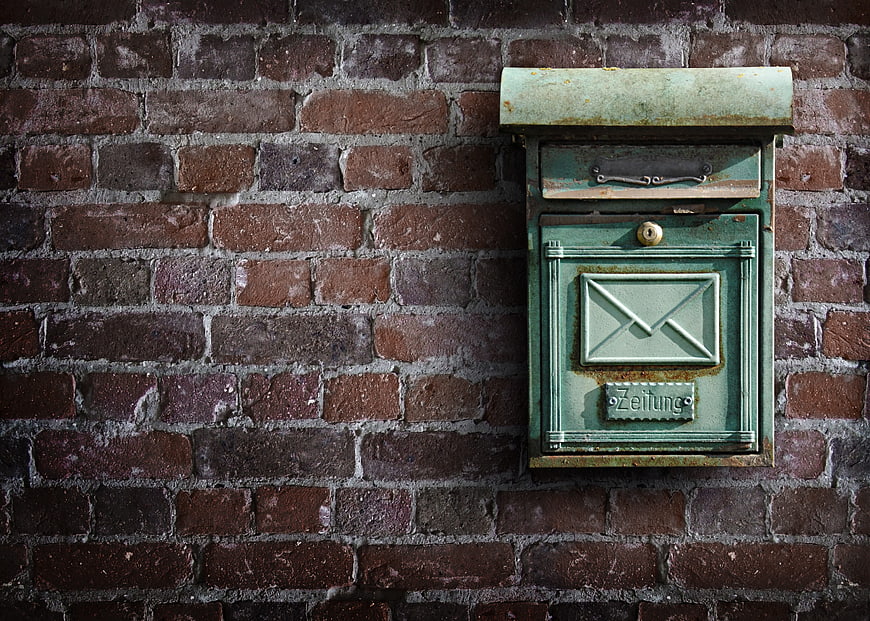 Vintage Green Mailbox on Weathered Brick Wall