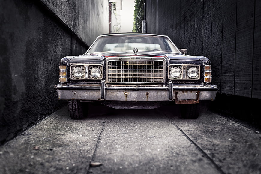 Front view of vintage black Ford car in narrow alley