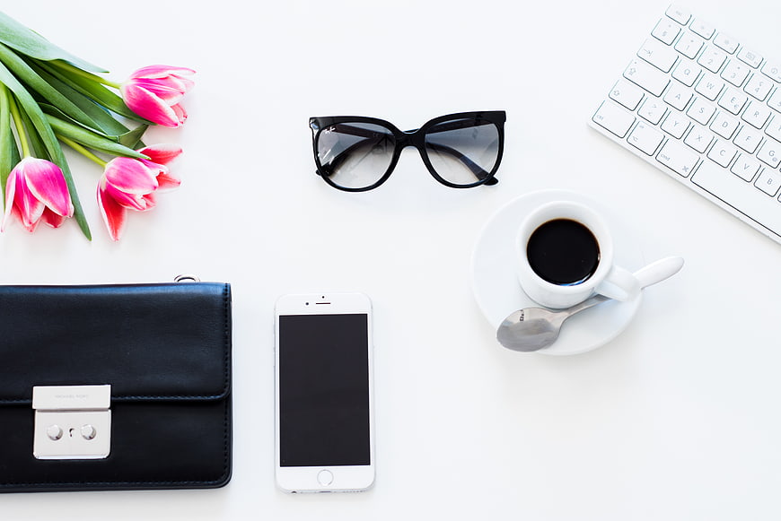Minimalist flat lay of office accessories and pink tulips
