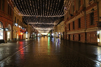 Empty Cobblestone Street with Christmas Lights at Night