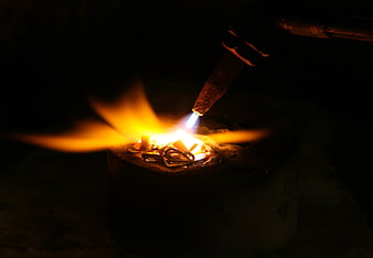 Close-up of metal melting with a blowtorch in a crucible