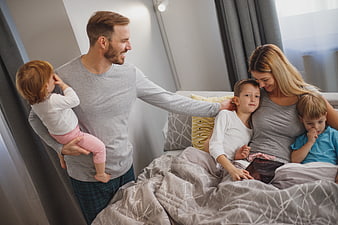 Happy family with children relaxing in bed together