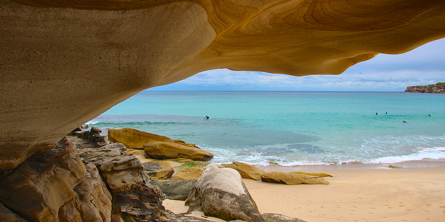 View of turquoise ocean from inside a sandstone rock cave