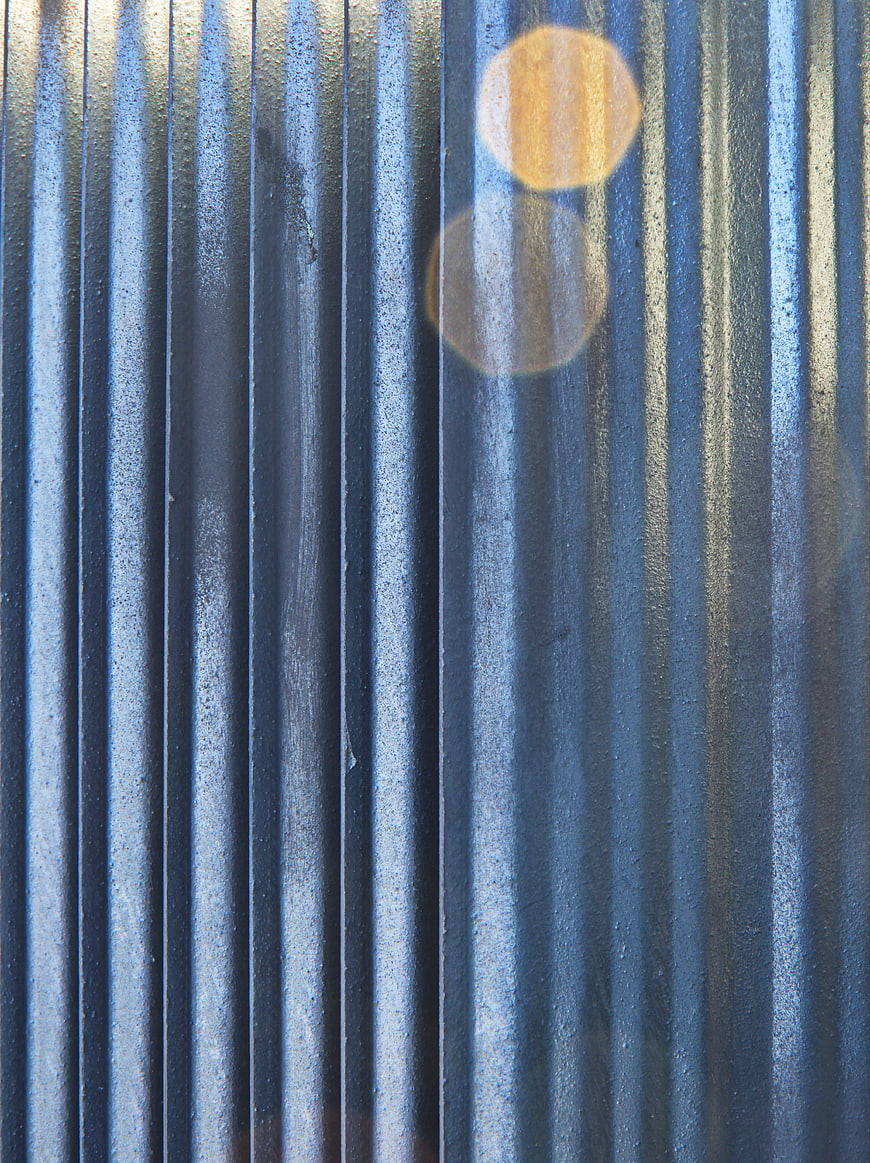 Abstract Blue Corrugated Metal Texture with Sunlight Flare