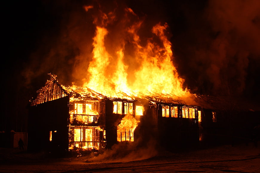 Large house engulfed in flames at night
