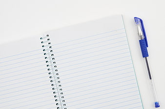 Blank spiral notebook and blue pen on white background
