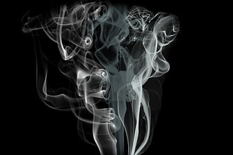 Abstract white smoke swirls on black background
