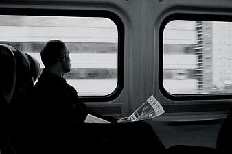 Silhouette of Man Reading Magazine on Moving Train