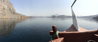 Traditional wooden boat sailing on calm desert lake
