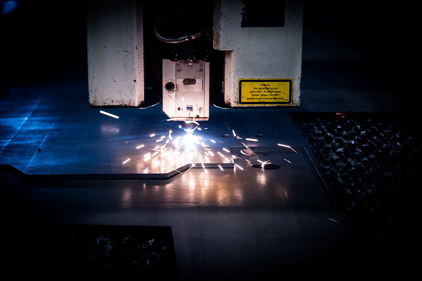 Industrial Laser Cutting Machine Creating Bright Sparks On Metal Sheet