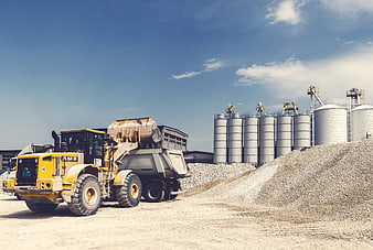 Yellow Wheel Loader Loading Gravel Truck at Industrial Silos