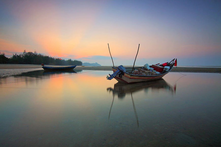 Traditional Longtail Boat on Calm Beach at Sunset
