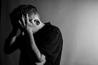 Black and white portrait of distressed man holding head