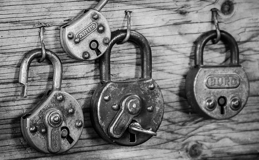 Vintage padlocks hanging on rustic wooden background