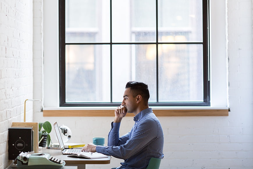 Thoughtful Man Working at Desk in Modern Office