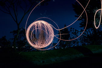 Steel wool light painting sparks at night in park