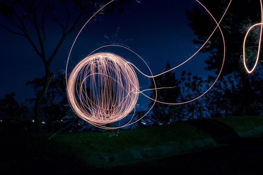 Steel wool light painting sparks at night in park