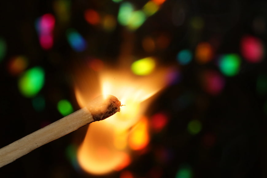 Burning Matchstick with Colorful Bokeh Background
