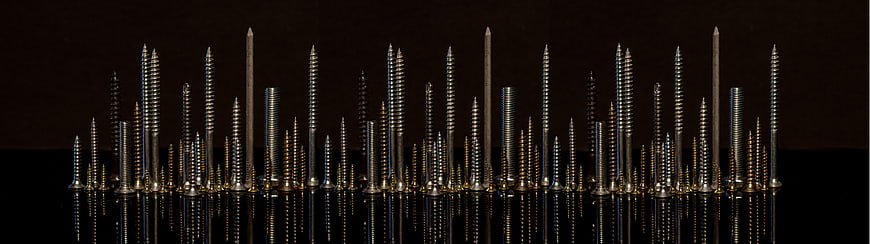 Macro Panorama of Metallic Screws and Nails on Black Background