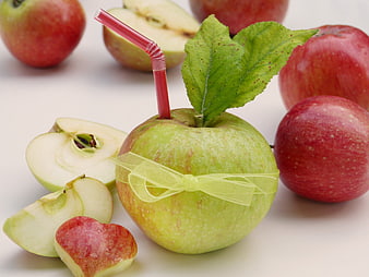 Creative Green Apple with Straw and Ribbon Surrounded by Red Apples