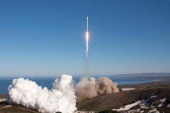Rocket Launching Vertically into Blue Sky with Smoke Trail